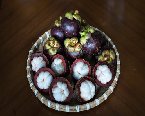 Fresh basket of tropical fruits on a wooden table